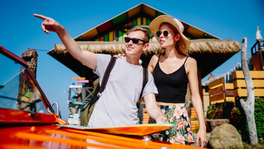 Young couple beach tour with a car