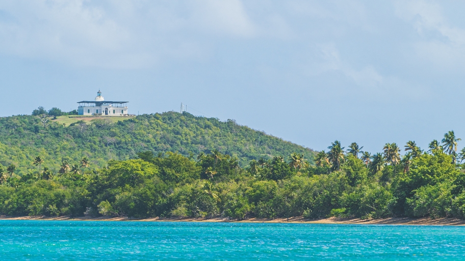 Lighthouse sits on a hill in Fajardo Puerto Rico surrounded by palm trees